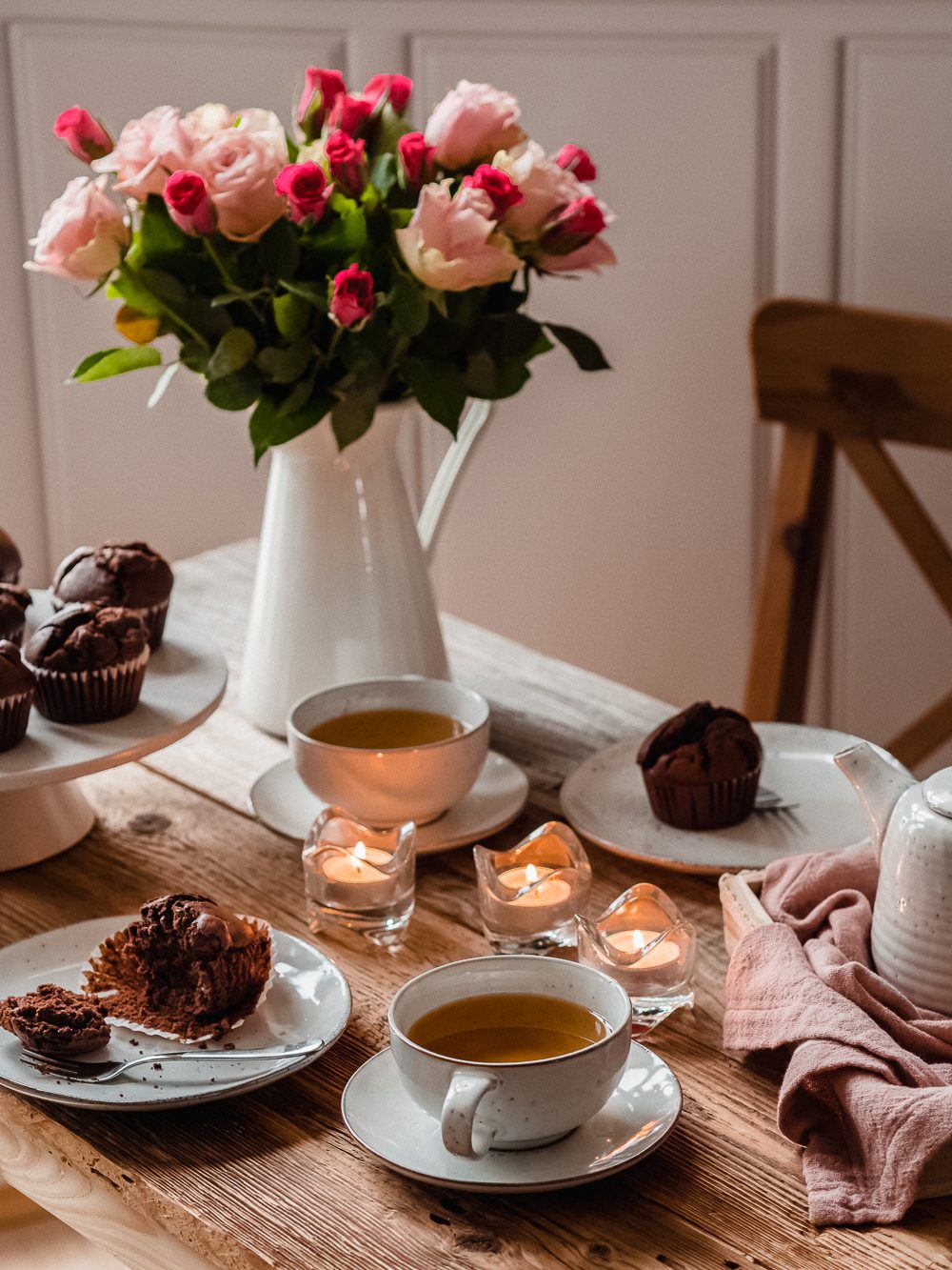 Schokoladen-Kirsch-Muffins auf einem Tisch mit Blumen